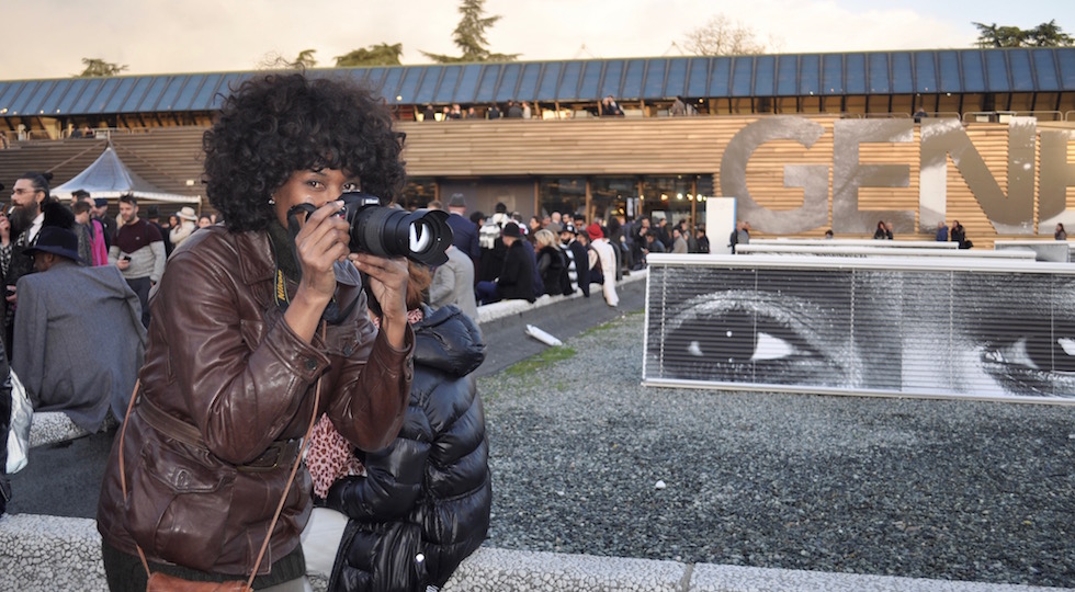 Una fotoreporter davanti agli stand affollati