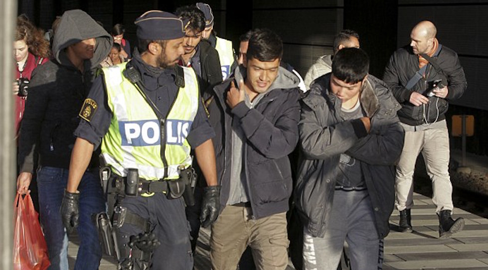 Un arrivo di migranti in Svezia controllato dalla polizia