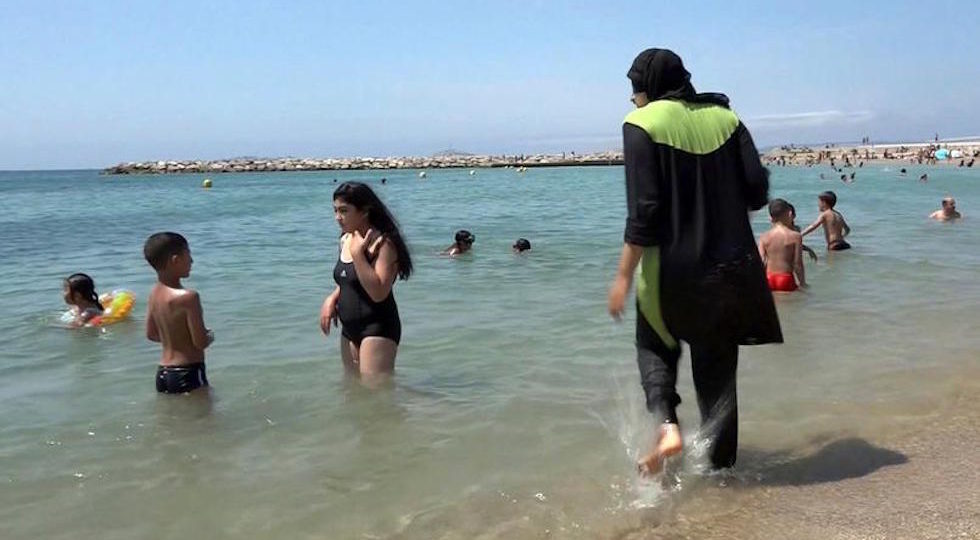 Una donna musulmana con il burkini su una spiaggia di Marsiglia