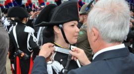 Un familiare appone l'alamaro dell'Arma sulla giacca di una neo allieva maresciallo