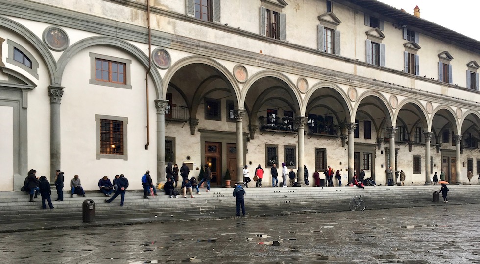 Persone in attesa di entrare alla mensa della Caritas in piazza Annunziata a Firenze