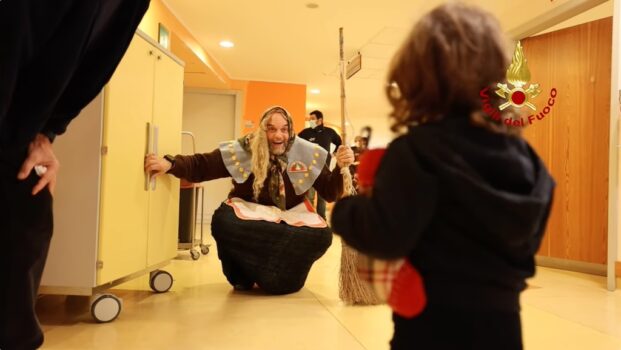 Un vigile del fuoco vestito da Befana tra i piccoli pazienti dell'Ospedale Pediatrico Meyer di Firenze
